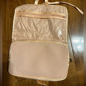 Peach colored, travel or cosmetic or jewelry bag. With 2  zippered compartments.